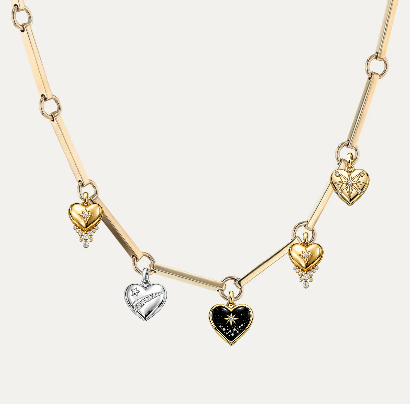 Charm Builder showcase — heart-shaped charms in gold and silver with gemstones